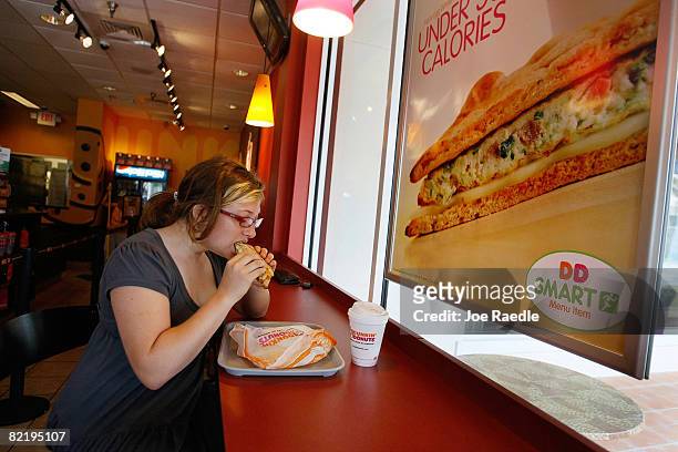 Meaghan Cooligan eats a Veggie Egg White Flatbread sandwich at a Dunkin' Donuts restaurant August 6, 2008 in Miami, Florida. The sandwich is one of...