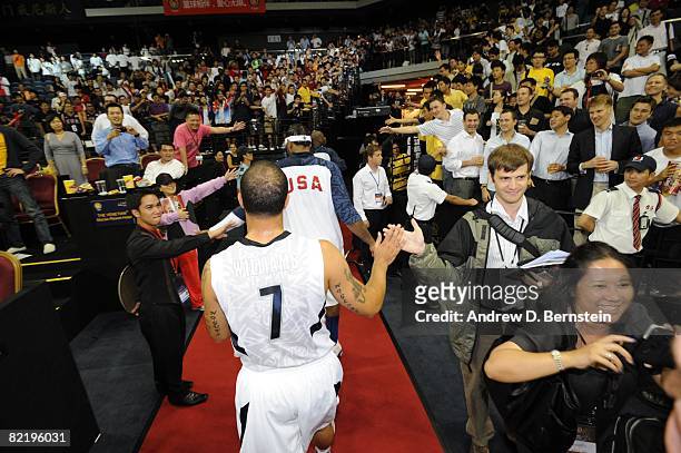 Deron Williams follows Carmello Anthony of the U.S. Men's Senior National Team greeting fans on their way to the locker room after a Pre-Olympics...