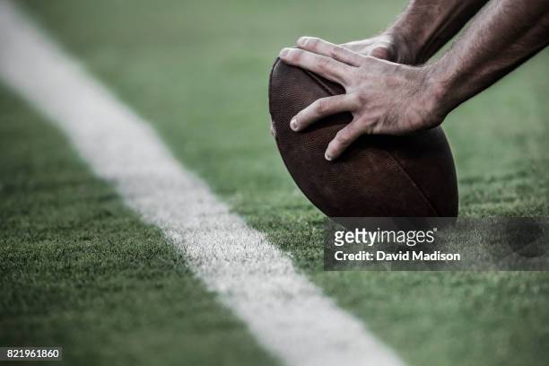 hands on an american football - american football sport stock pictures, royalty-free photos & images
