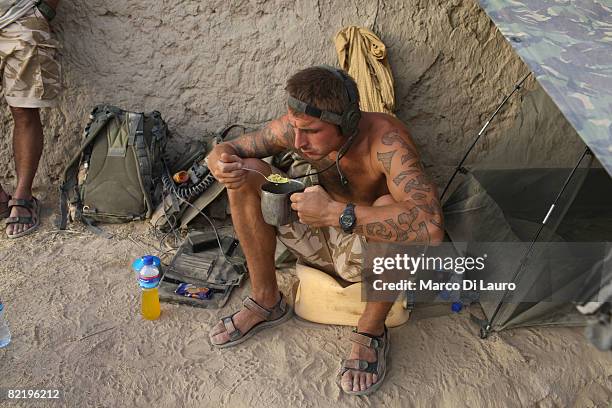 British Army soldier from the 3rd Battalion The Parachute Regiment eats his 'ready to eat' individual meal ration during operation Southern Beast on...