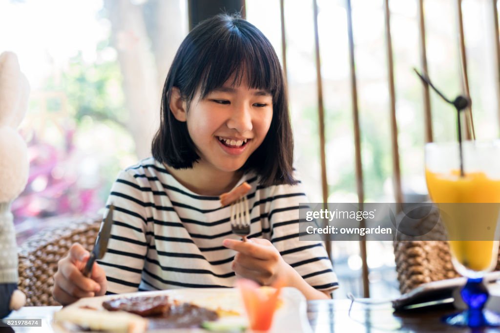 Teenage girl using smartphone in the restaurant