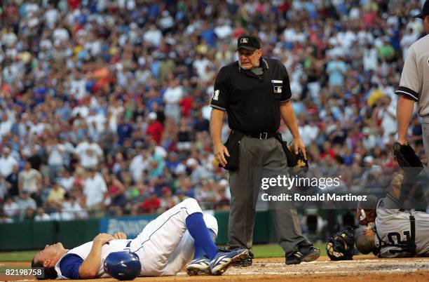 David Murphy of the Texas Rangers lies on the ground after a collision at homeplate with catcher Ivan Rodriguez of the New York Yankees on August 6,...