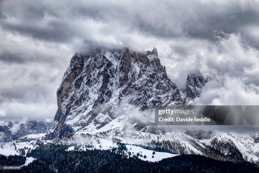 The 'Sasso Piatto' rock formation in the Dolomites among fog and clouds