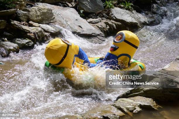 Tourists dressed as Minions drift in a river at Lianyuan on July 24, 2017 in Loudi, Hunan Province of China. Tourists in the Minions costumes enjoyed...