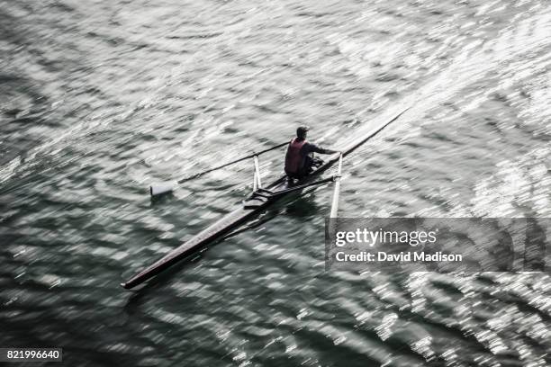 man rowing on lake - single scull stockfoto's en -beelden