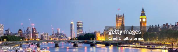 panoramic view of westminster bridge and westminster palace with big ben at dusk - panoramic skyline stock pictures, royalty-free photos & images