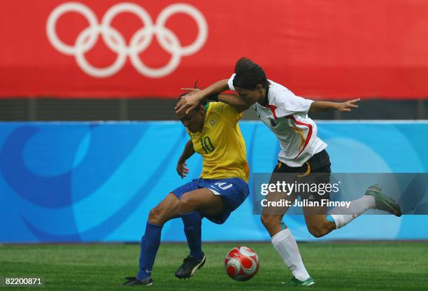 Marta of Brazil tangles with Linda Bresonik of Germany during the women's preliminary group F match between Germany and Brazil at Shenyang Stadium...