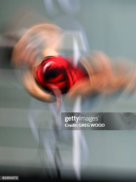 Member of the Russian women's diving team twists and turns in this slow shutter effect photograph at the National Aquatics Center, otherwise known as...