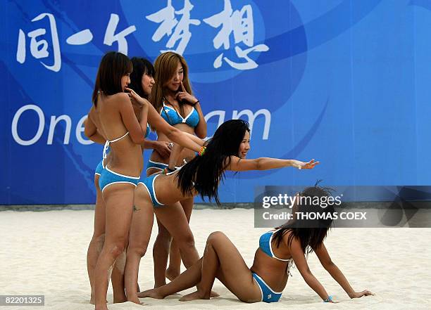 Chinese cheerleaders perform during volleyball team's training sessions at Beijing's Chaoyang Park Beach volleyball ground on August 7, 2008 on the...