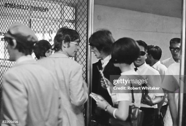 John Lennon and George Harrison at Manila International Airport after the Philippines leg of the Beatles' final world tour, 5th July 1966. The group...