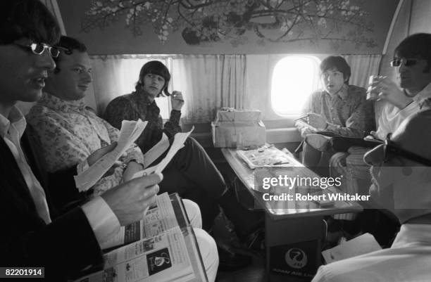 The Beatles on a Japan Airlines flight from Hong Kong to Manila during their final world tour, 3rd July 1966. Clockwise from left: George Harrison ,...