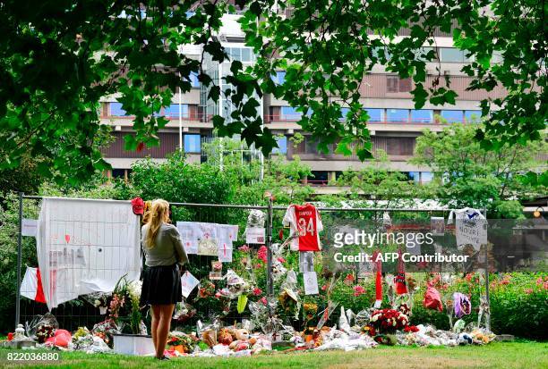 Visitor stands in silence next to items placed by the hospital where the Ajax midfielder Abdelhak Nouri receives treatments in Amsterdam on July 22,...