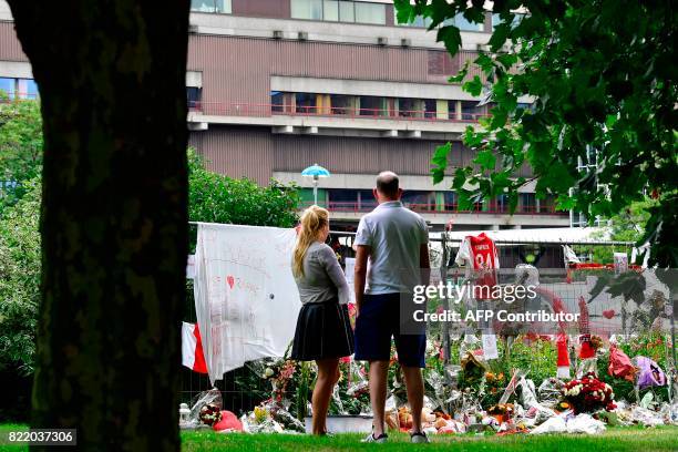 Visitors stand in silence next to items placed by the hospital where the Ajax midfielder Abdelhak Nouri receives treatments in Amsterdam on July 22,...