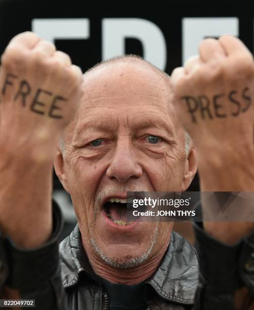 Man with the words 'free press' written on the backs of his hands protests alongside Amnesty International activists and partners outside the...