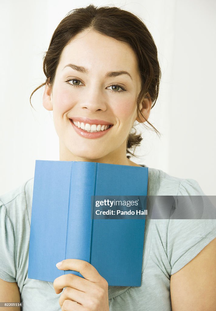 Young woman with book, smiling