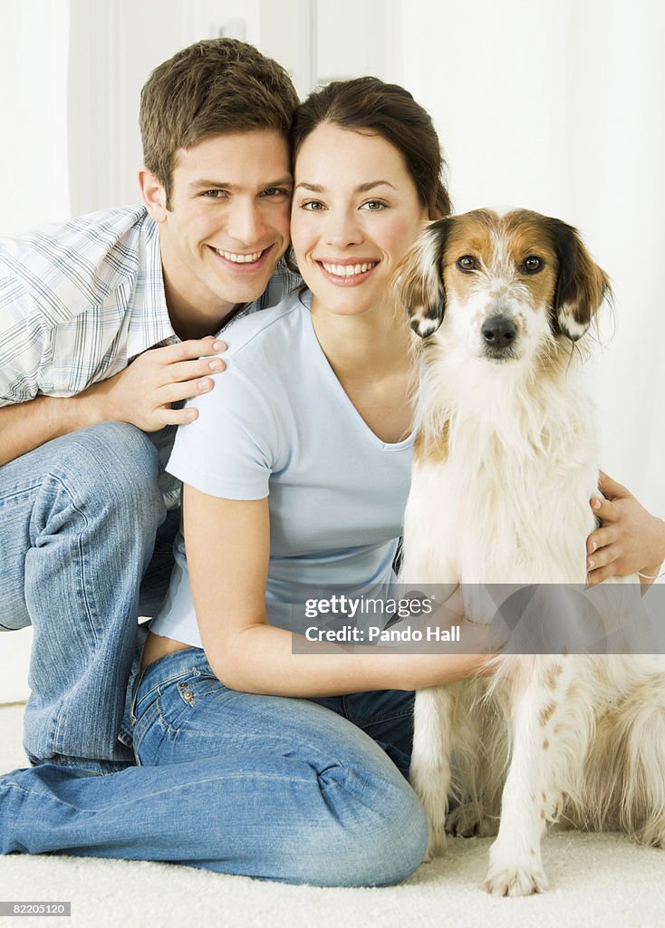 Young couple with dog, smiling