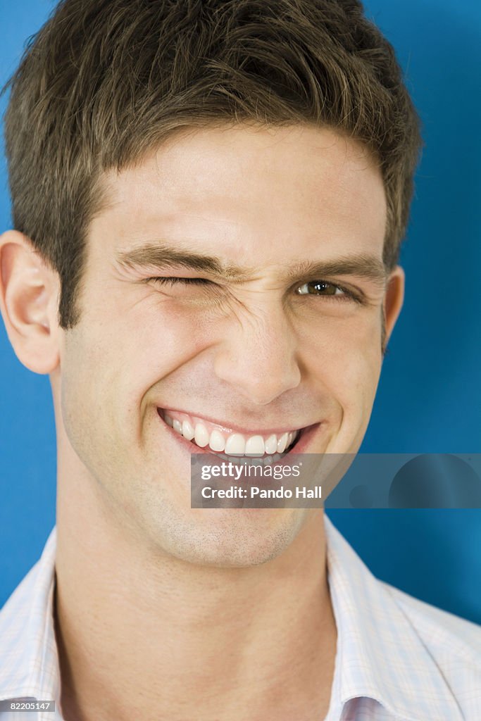 Young man winking, smiling, portrait