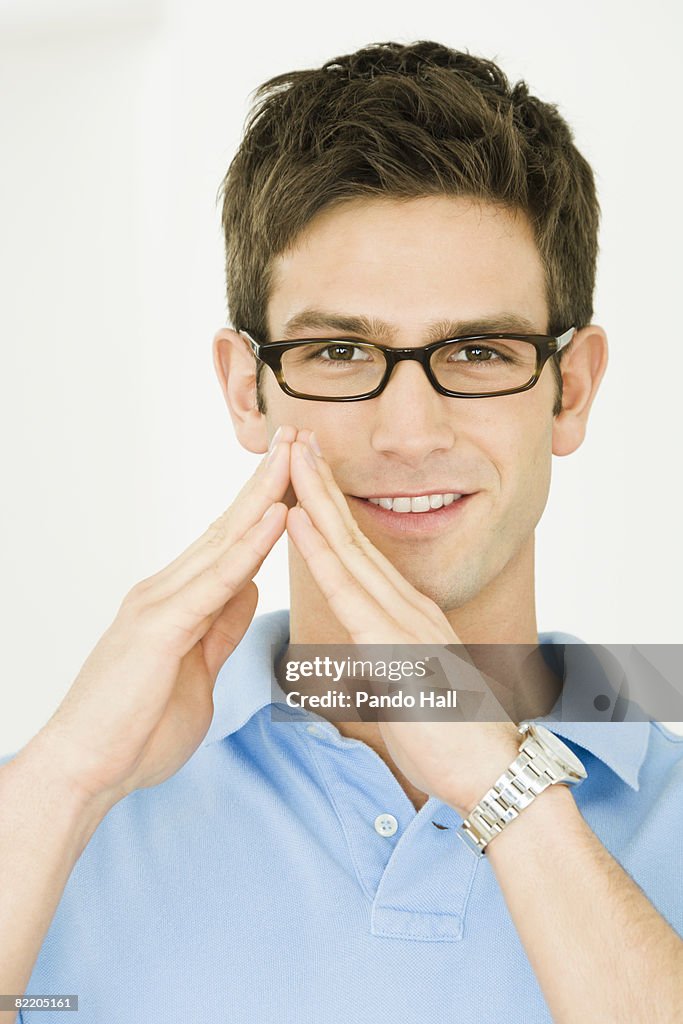 Young man making triangle shape with hands