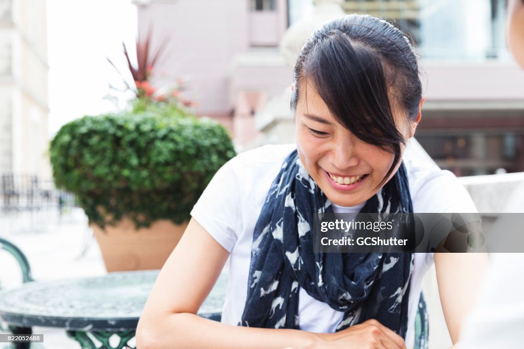 Japanese lady laughing at the topic of the conversation