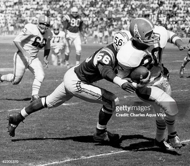 Houston Oilers running back Billy Cannon tries to avoid the tackle of San Diego Chargers linebacker Emil Karas during a 34-24 Chargers victory on...