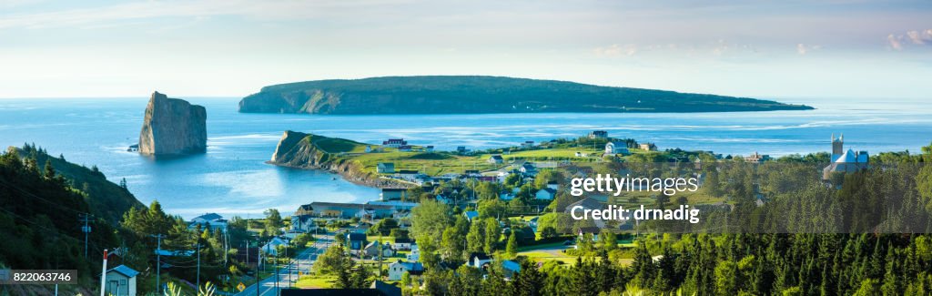 Panorama von Perce Rock in Quebec, Kanada mit Pinien in den Vordergrund und blaue Wasser des St.-Lorenz-Golf