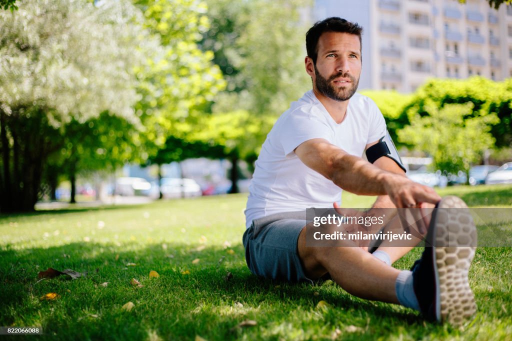 Mannen stretching innan morgon träning