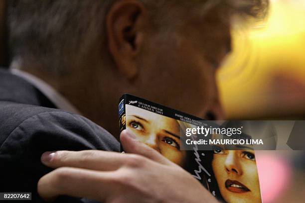 Fan, holding a DVD cover of "Mulholland Drive", touches the shoulder of US filmmaker David Lynch after getting his autograph during an autograph...