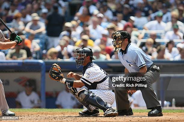 Jorge Posada of the New York Yankees and home-plate umpire James Hoye await the pitch during the game against the Oakland Athletics at Yankee Stadium...