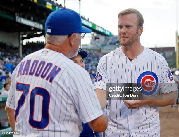 Former Chicago Blackhawks player Bryan Bickell shakes hands with manager Joe Maddon of the Chicago Cubs after throwing out a ceremonial first pitch...