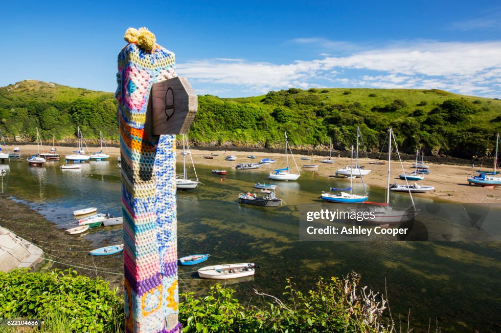 Solva Harbour, Pembrokeshire, UK with a yarn bombed signpost.