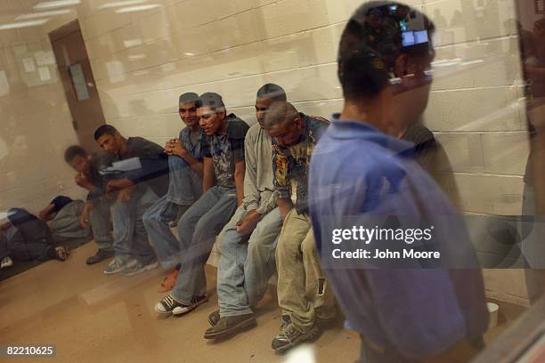 Illegal immigrants sit in a holding cell at a U.S. Border Patrol station after they were caught crossing from Mexico into the United States August 7,...