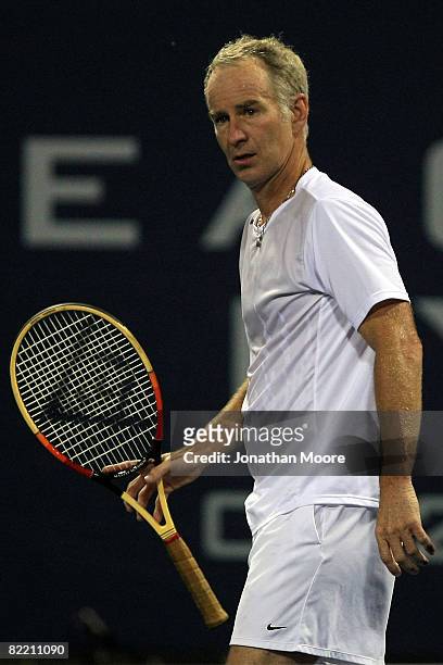 John McEnroe looks on during a pause in action against Mikael Pernfors of Sweden during day four of the Countrywide Classic at the Los Angeles Tennis...