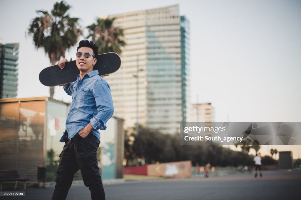 Chinese man carrying skateboard