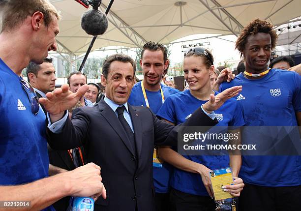 French President Nicolas Sarkozy is greeted by French swimmers Alain Bernard and Laure Manaudou , tennis player Gael Monfils and Michael Llodra as he...