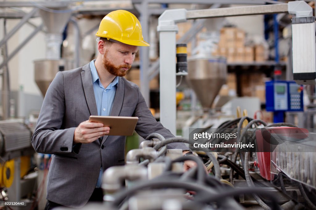 Male engineer checking pressure in machines in factory