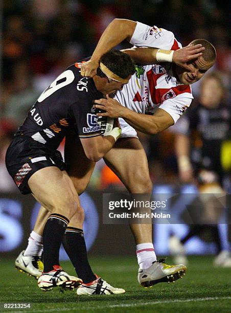 John Morris of the Tigers palms off Dan Hunt of the Dragons during the round 22 NRL match between the St George-Illawarra Dragons and the Wests...