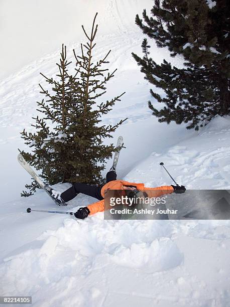 woman skier lying on her back by tree - female skier stockfoto's en -beelden