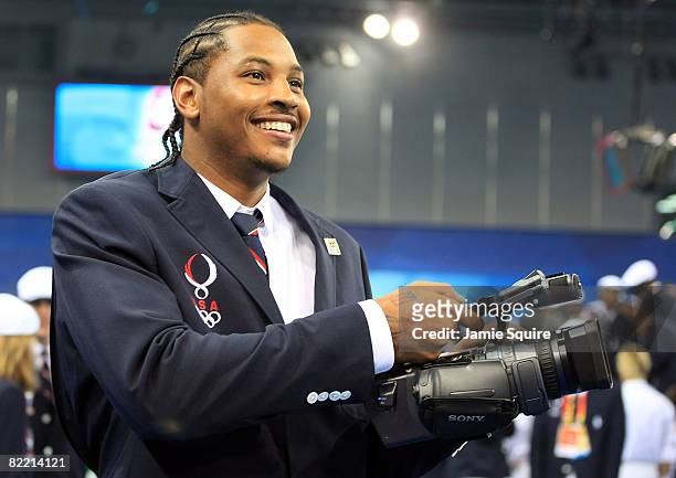 Basketball player Carmelo Anthony of the United States records video during a visit by US President George W. Bush on the opening day of the Beijing...