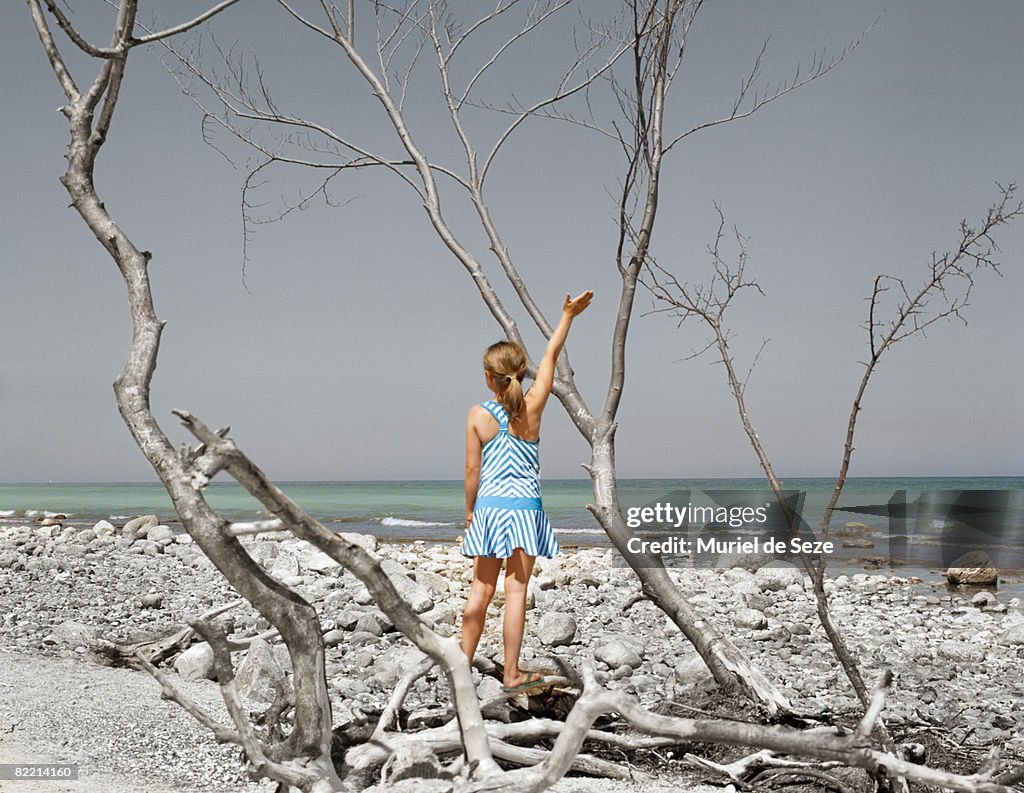 Girl waving from deserted landscape