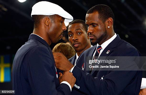 Basketball player LeBron James of the United States adjust the tie of Olympic teammate Kobe Bryant during a visit by US President George W. Bush on...