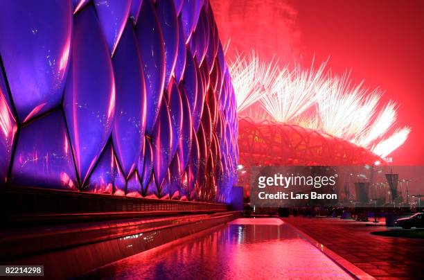 Fireworks light the sky over the National Aquatics Center and the National Stadium during the Opening Ceremony for the 2008 Beijing Summer Olympics...
