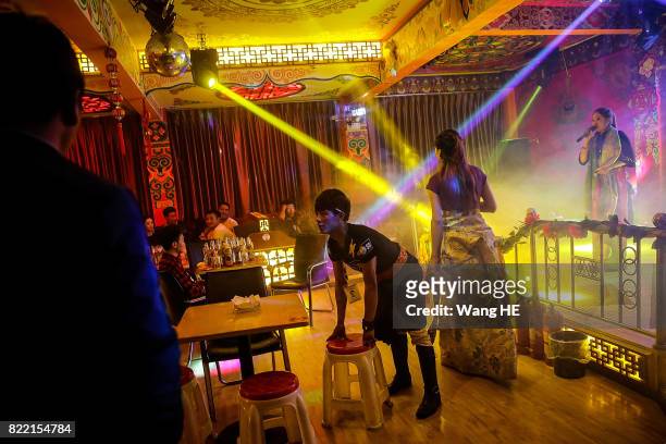The barman checks the table as a actors perform in Tibetan Bar on July 22 ,2017 in Litang County, southwest of Garze Tibetan Autonomous Prefecture,...