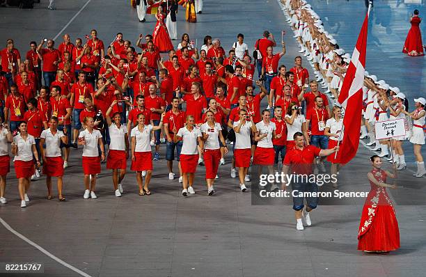 Joachim B. Olsen of the Denmark Olympic track and field team carries his country's flag to lead out the delegation during the Opening Ceremony for...