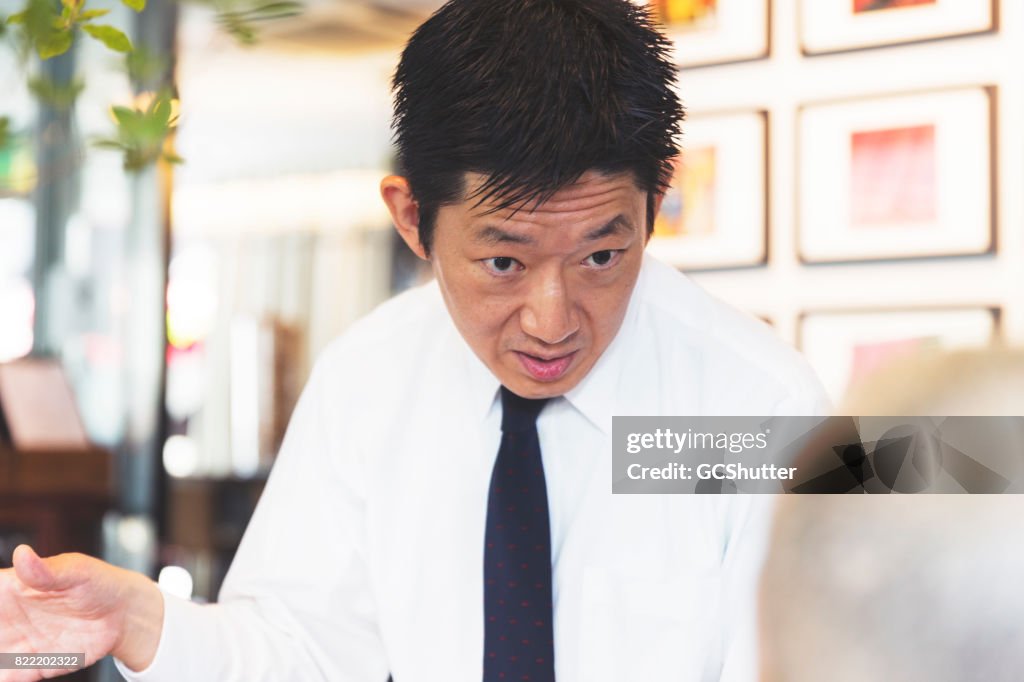 Businessman having a stern conversation with a colleague