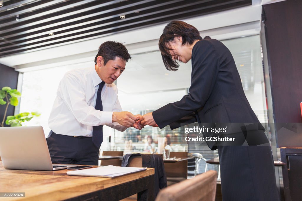 Female business executive handing over her card to the businessman