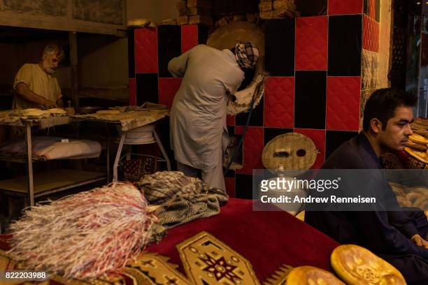 Men make naan on July 24, 2017 in Kabul, Afghanistan. Despite a heavy security presence throughout the city, life remains under constant threat of...