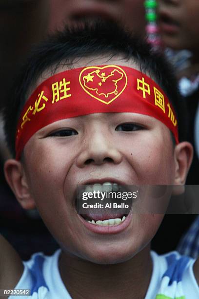 Young man cheers outside The National Musem of China at Tiananmen Square during the Opening Ceremony for the 2008 Beijing Summer Olympics at...