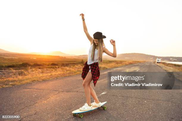 schöne frau longboarden auf landstraße - longboard stock-fotos und bilder