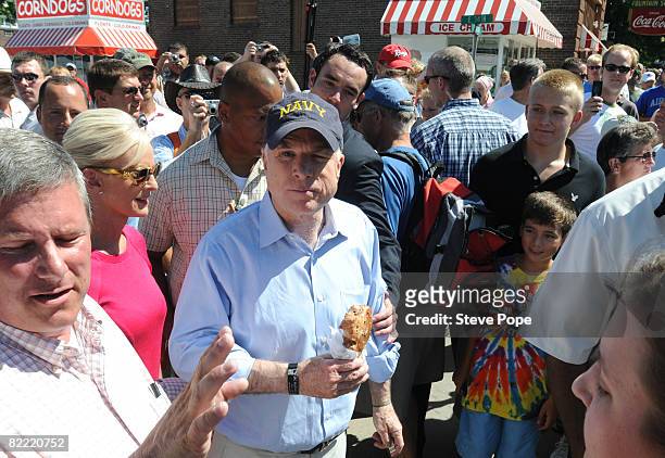 Republican presidential candidate Senator John McCain eats a pork chop on a stick during a campaign stop at the Iowa State Fair August 8, 2008 in Des...