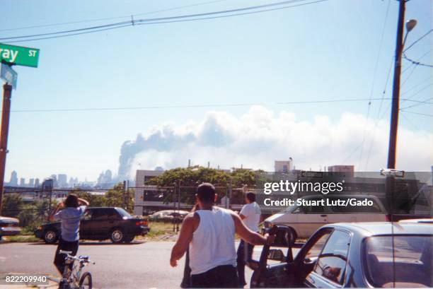 During the terrorist attacks of September 11 motorists exit their cars in disbelief and look on as smoke rises from the buildings of the World Trade...